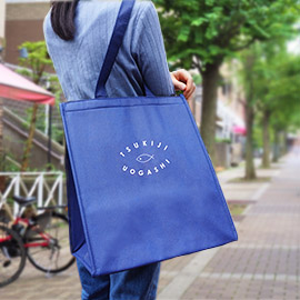 築地魚河岸事業協議会様の保冷バッグを肩にかけて使用した様子